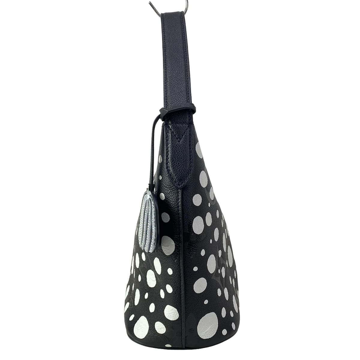 Patterned handbag covered in repeating dot motifs with leather trim and a top handle.