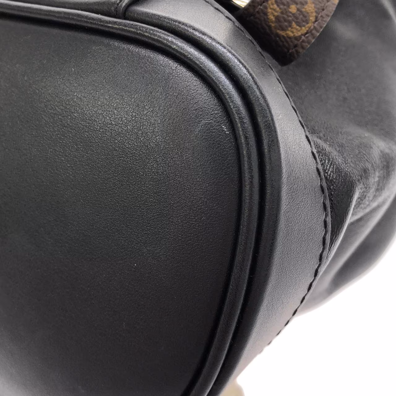 Brown monogram backpack with front flap pocket, buckled straps and adjustable shoulder straps.