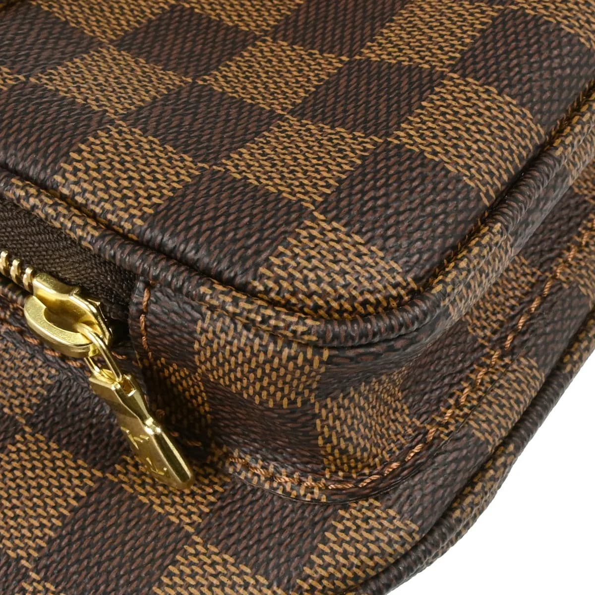 Brown checked coated canvas belt bag with leather trim and a buckled strap, photographed against a plain backdrop