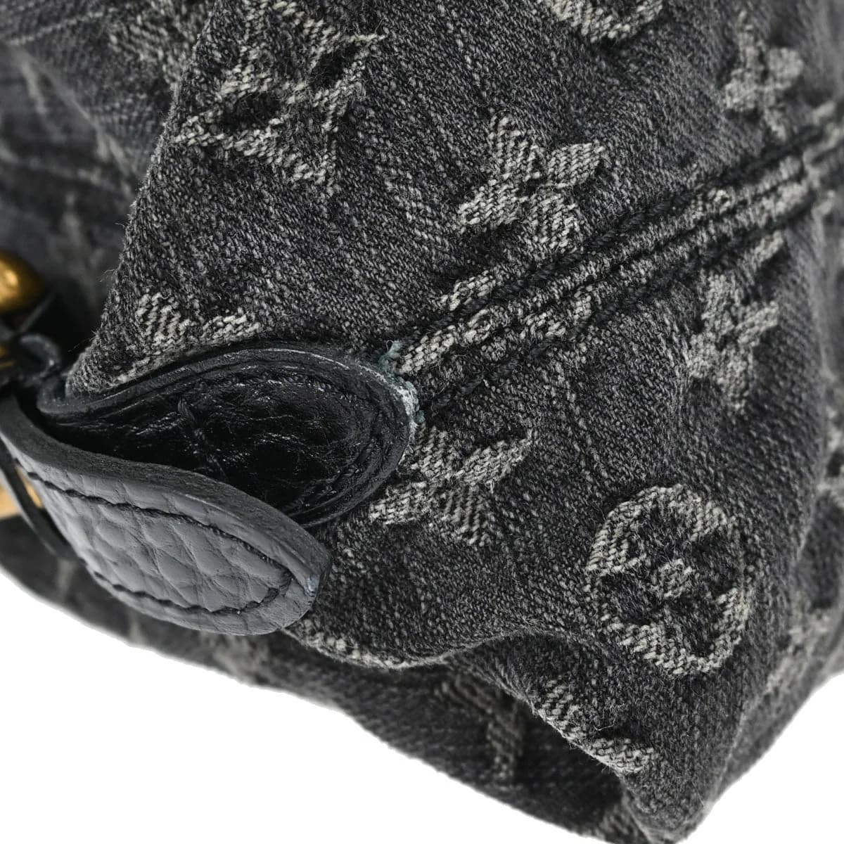 Black denim tote with woven monogram pattern, rolled handles and a detachable strap.