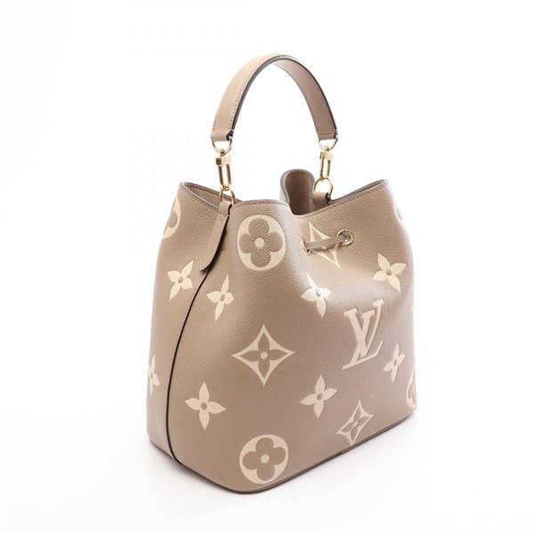 Product photograph of a two-tone bucket bag with drawstring sides and a shoulder strap.