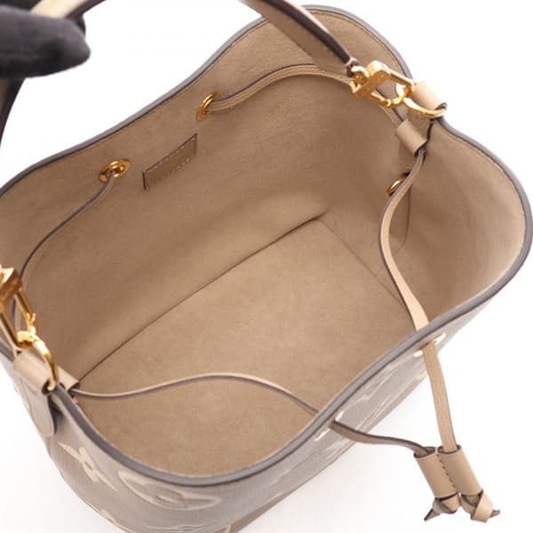 Product photograph of a two-tone bucket bag with drawstring sides and a shoulder strap.