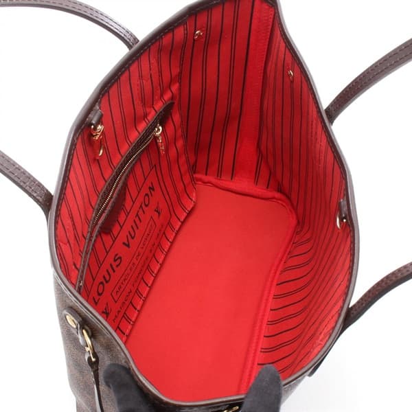 Brown checkered canvas open tote with long leather straps, standing upright.