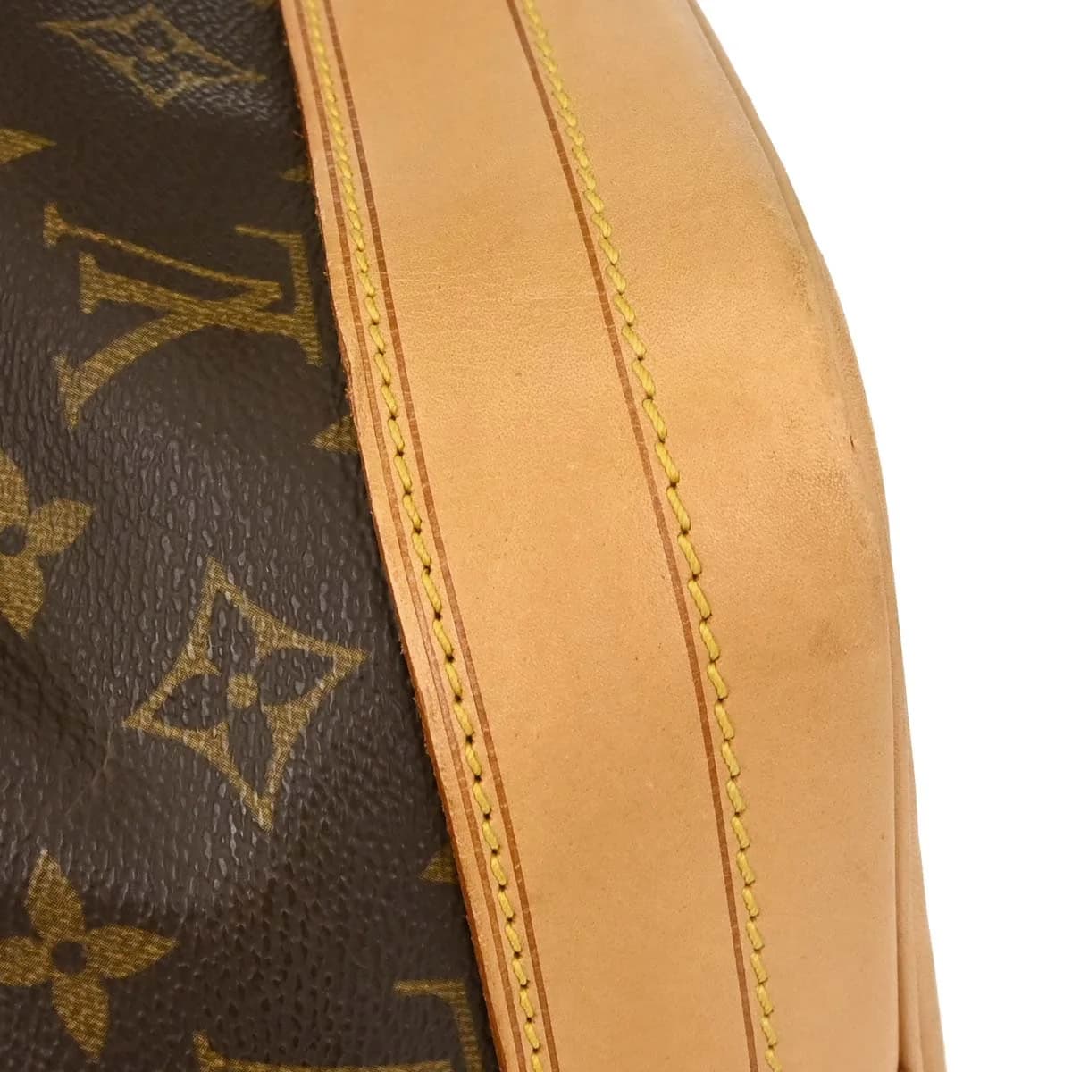 Brown monogram canvas bucket bag with drawstring top and single shoulder strap.