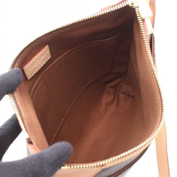 Brown monogram-pattern coated canvas flap crossbody bag with a wide adjustable strap.