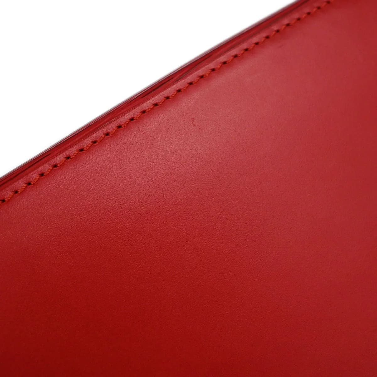 Small structured red textured-leather handbag with short handles and a flap top.