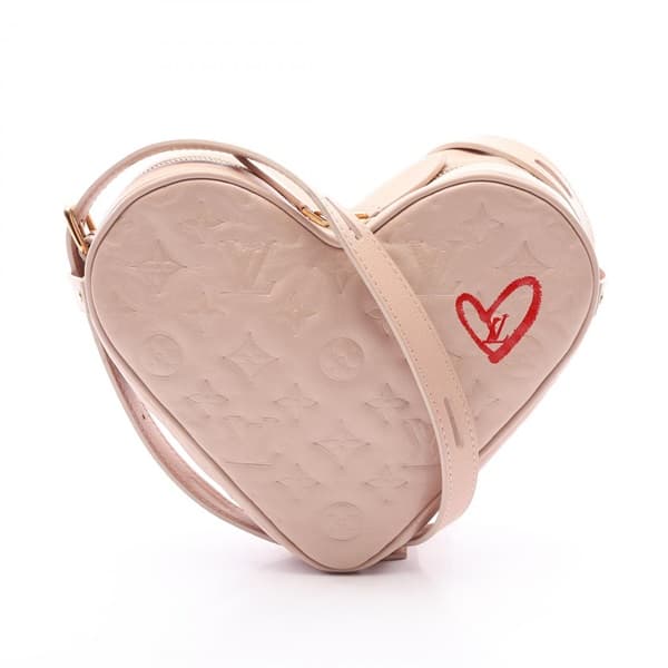 Product photograph of a pink heart-shaped bag with a chain and leather shoulder strap.