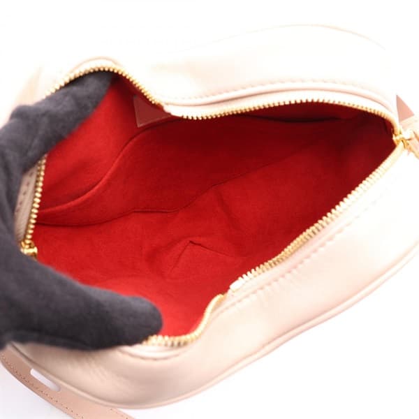 Product photograph of a pink heart-shaped bag with a chain and leather shoulder strap.