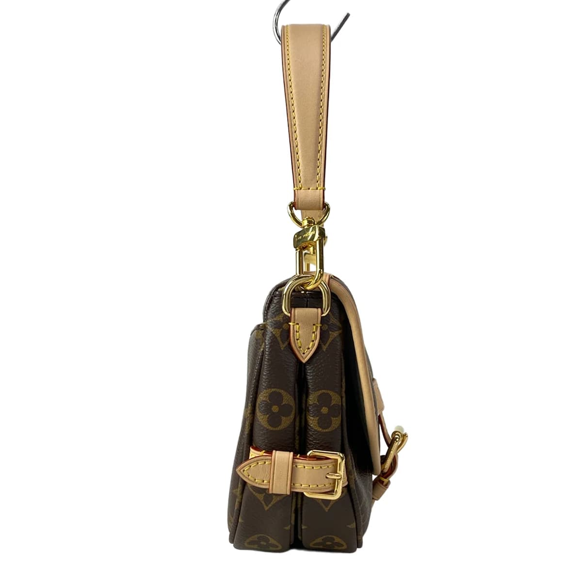 Small monogram-canvas saddle-style bag with a buckled flap and shoulder strap.