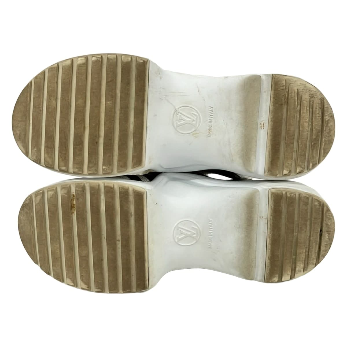 Dark brown and white low-top trainers shown from the side.