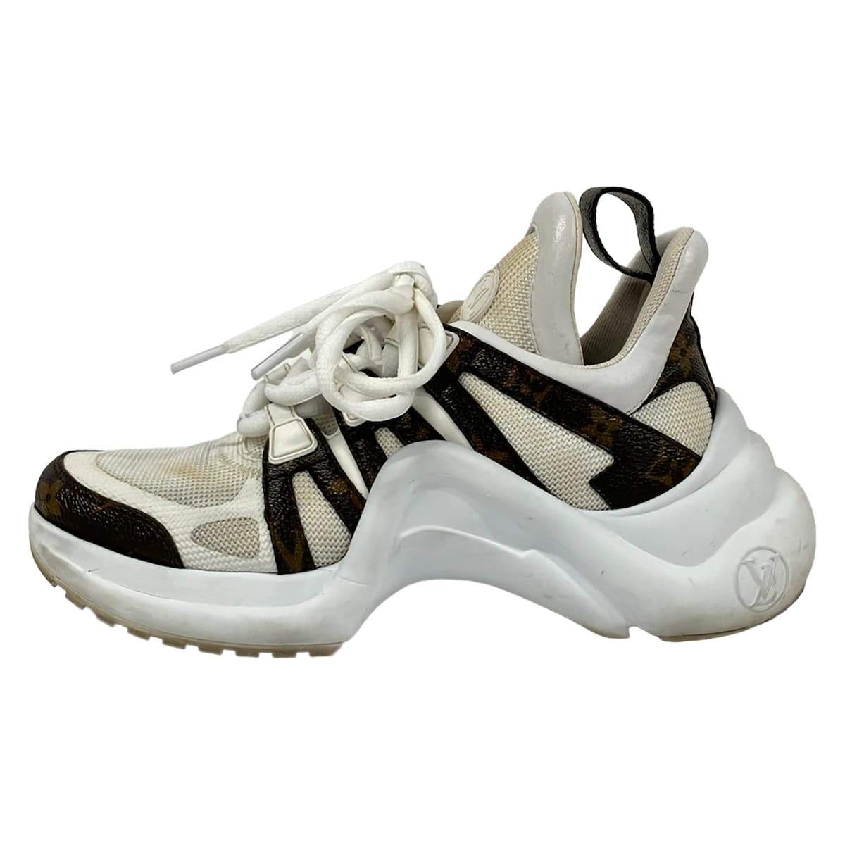 Dark brown and white low-top trainers shown from the side.