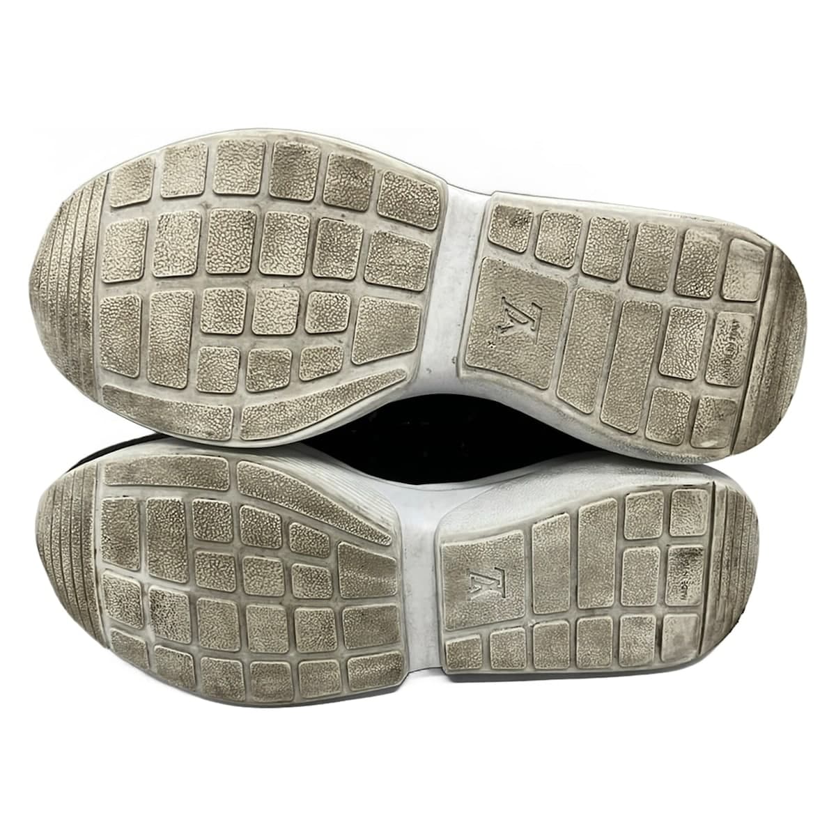Black shoe with transparent panels and sparkling jewel trim, on a plain background.