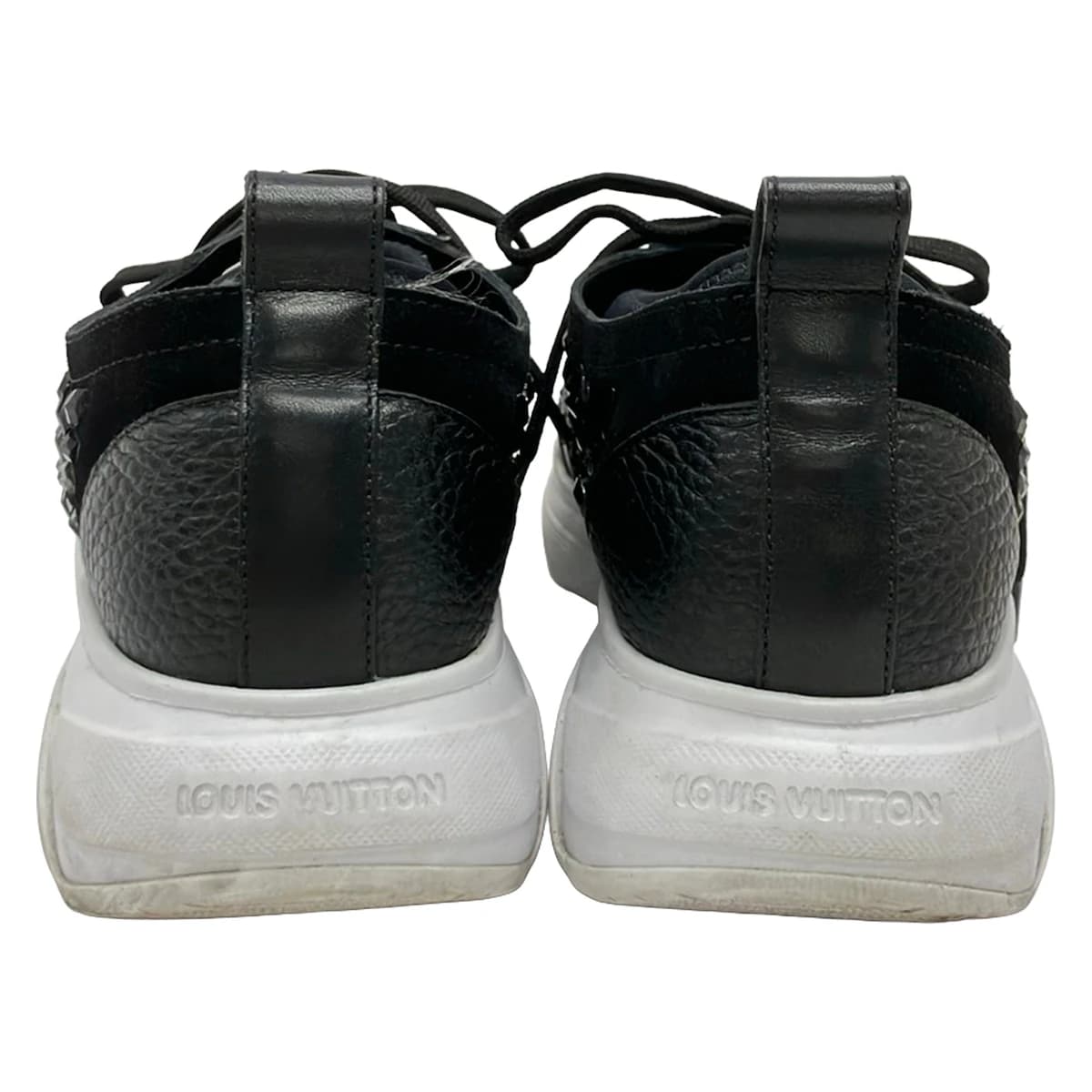 Black shoe with transparent panels and sparkling jewel trim, on a plain background.