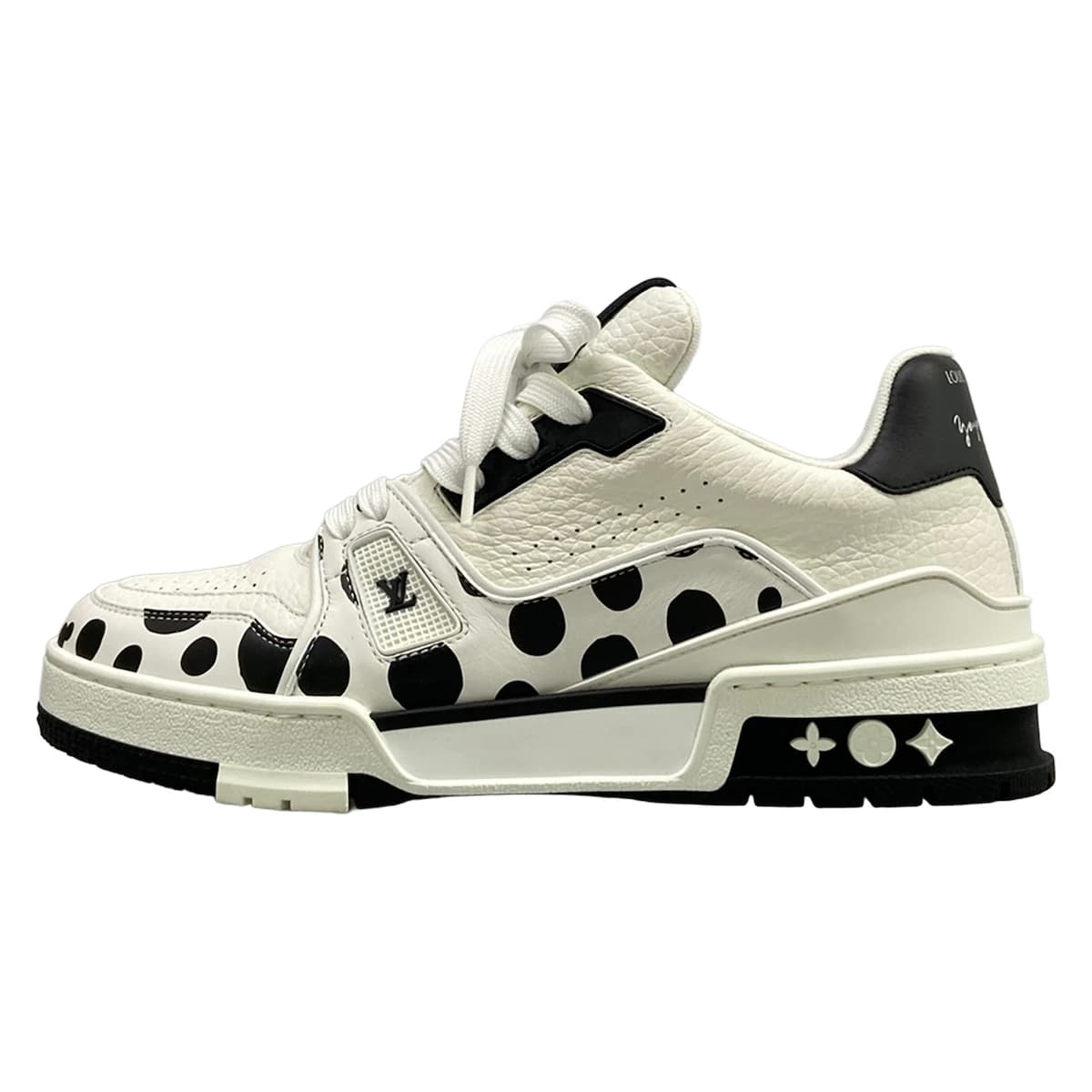 White leather trainers with black trim, viewed from the side.
