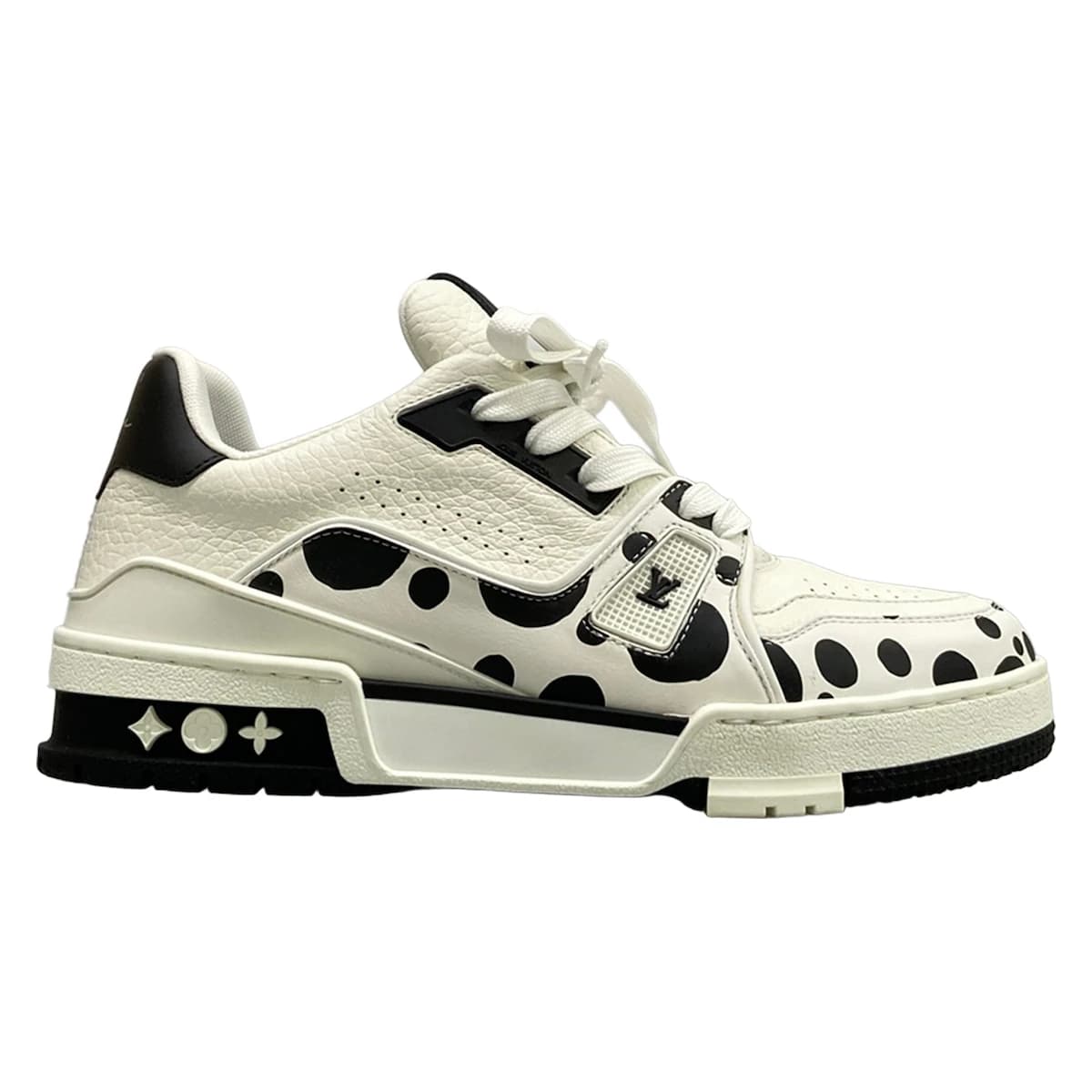 White leather trainers with black trim, viewed from the side.