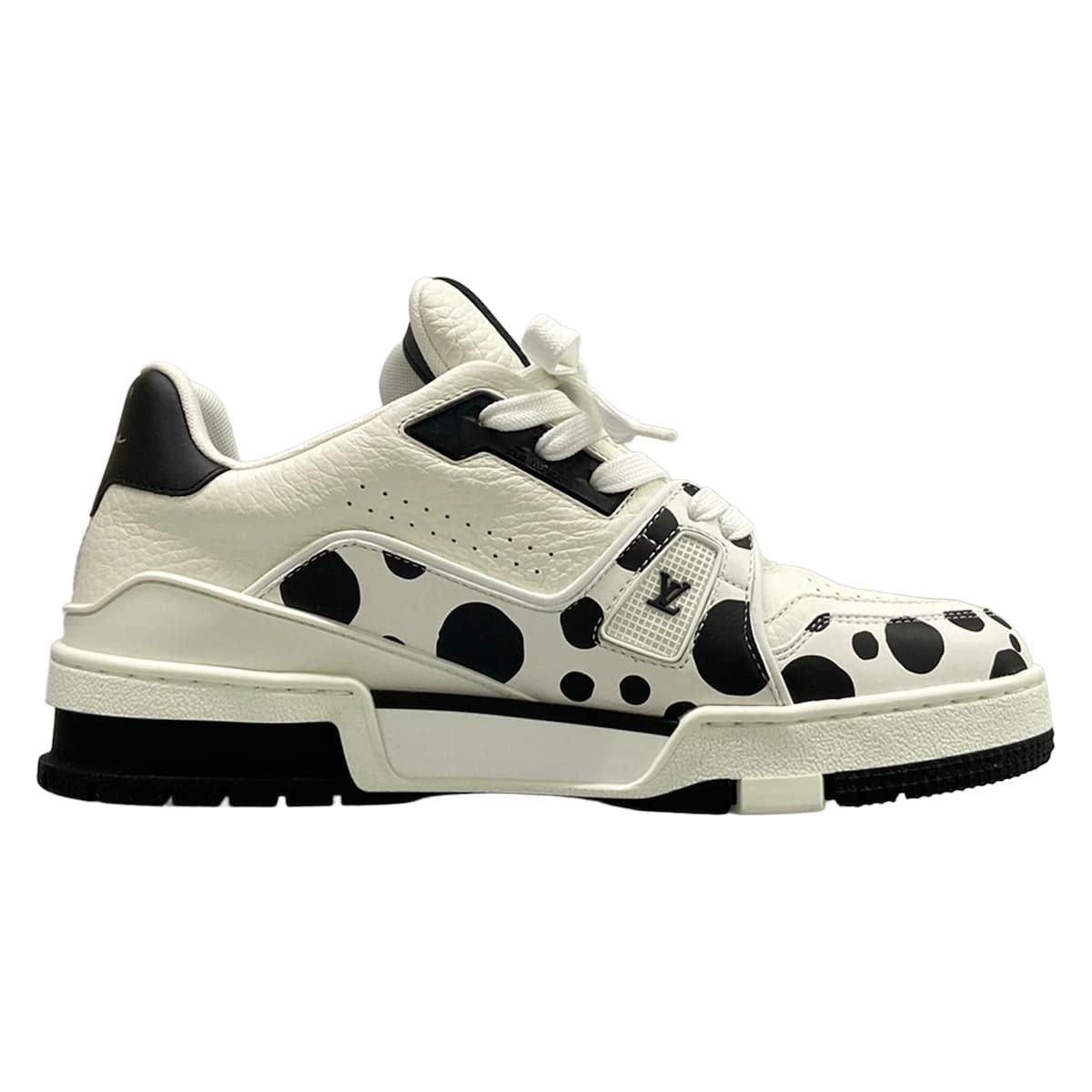 White leather trainers with black trim, viewed from the side.