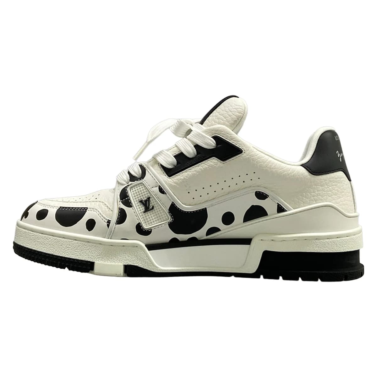 White leather trainers with black trim, viewed from the side.
