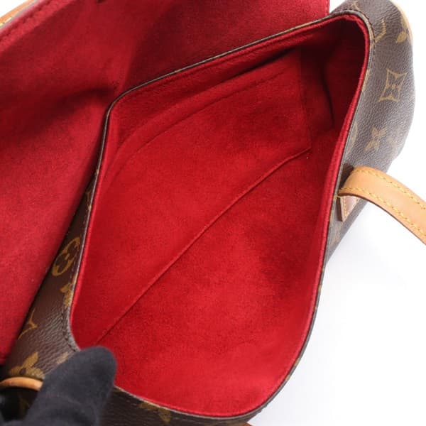 Small brown monogram-pattern coated canvas handbag with a short rolled handle and front flap.
