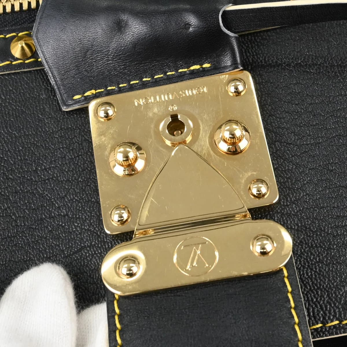 Black textured leather handbag with rolled handles and polished hardware.