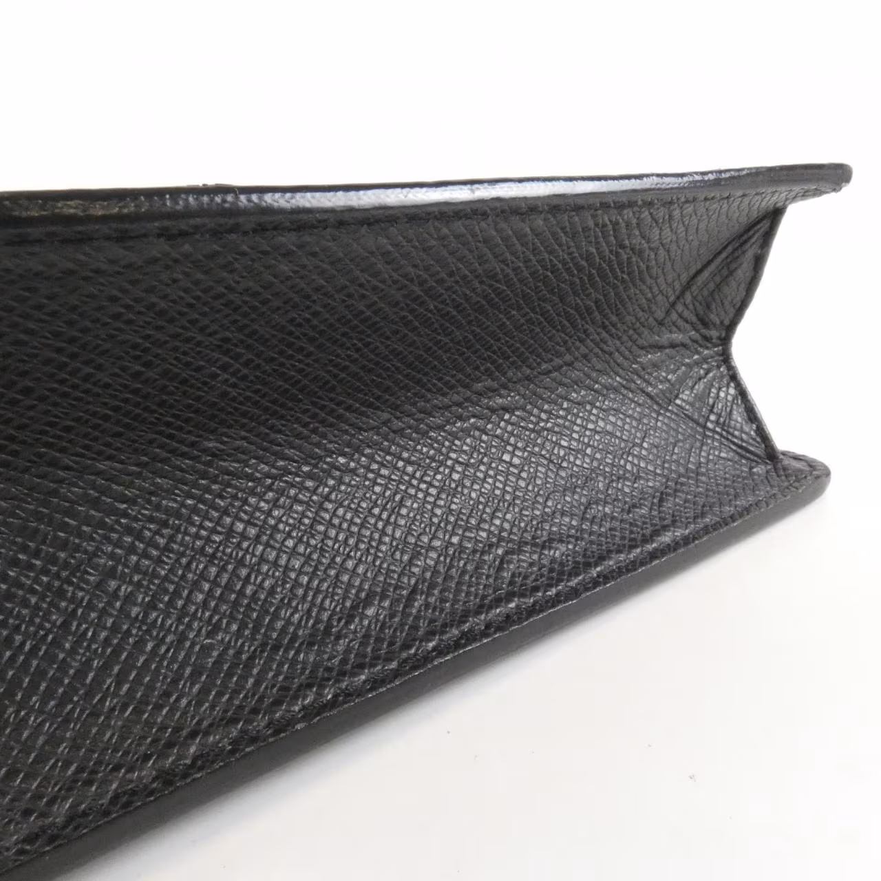 Compact grained leather shoulder bag with slim strap and zip closure.