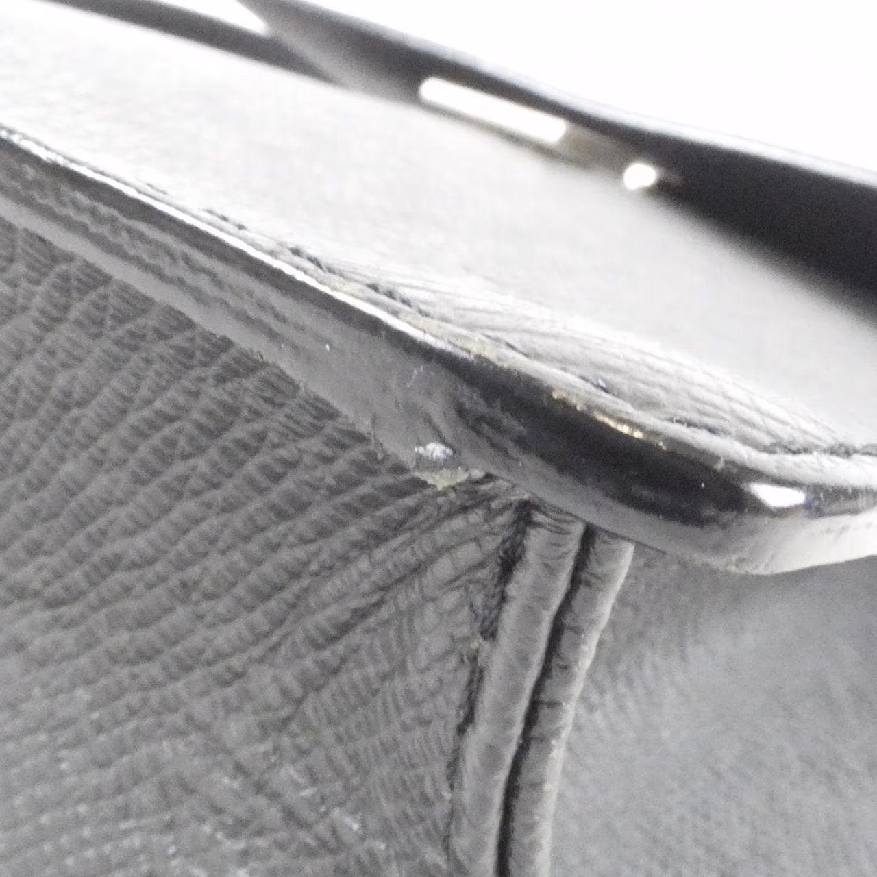 Compact grained leather shoulder bag with slim strap and zip closure.