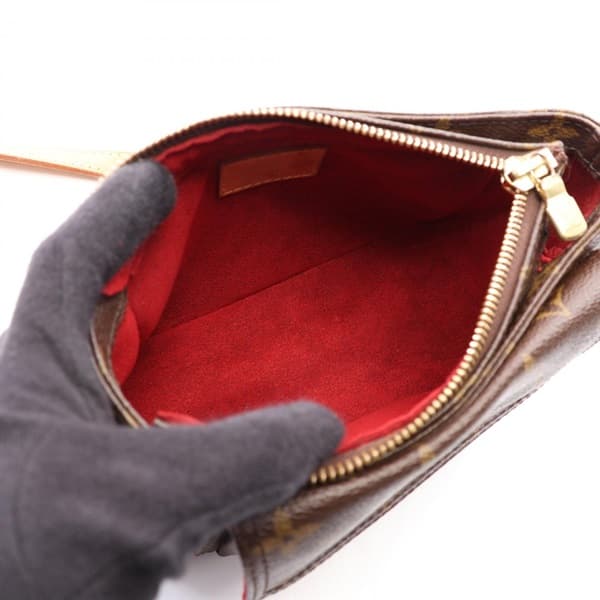 Small brown monogram shoulder bag with curved top and single strap.
