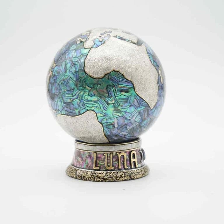 Product photograph of a small rounded vinyl figure with iridescent shell inlay decoration.