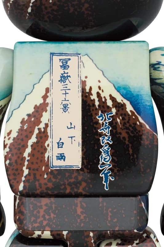 Large bear-shaped figure printed all over with a woodblock print of a mountain under a dark sky.