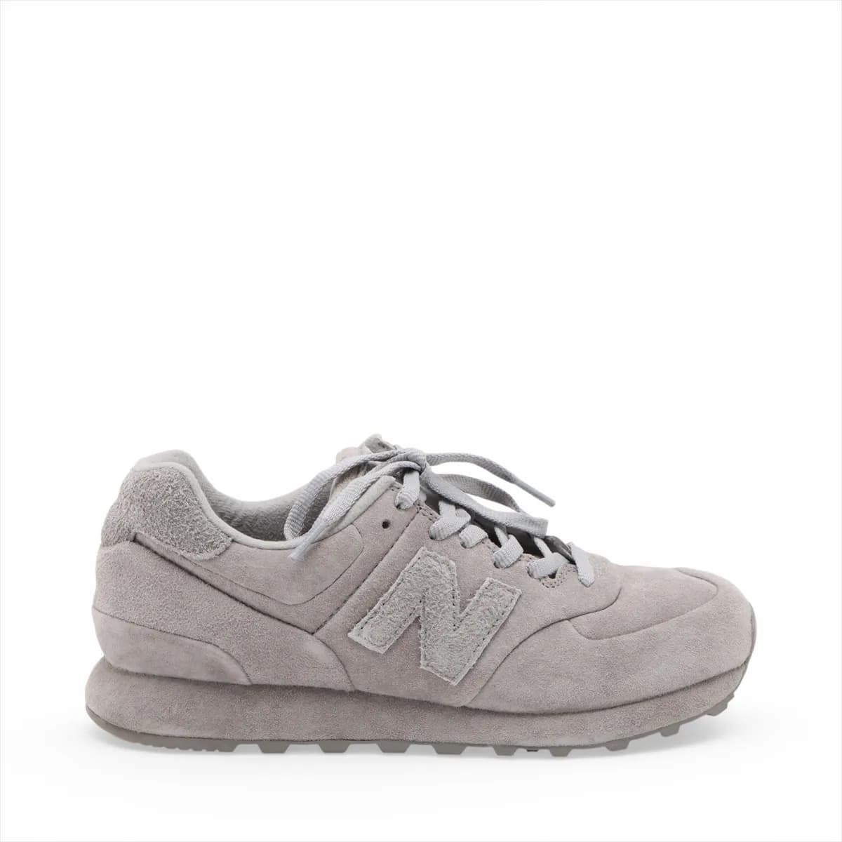 Pair of low-top grey suede sneakers in side view with mesh panelling and a white midsole.