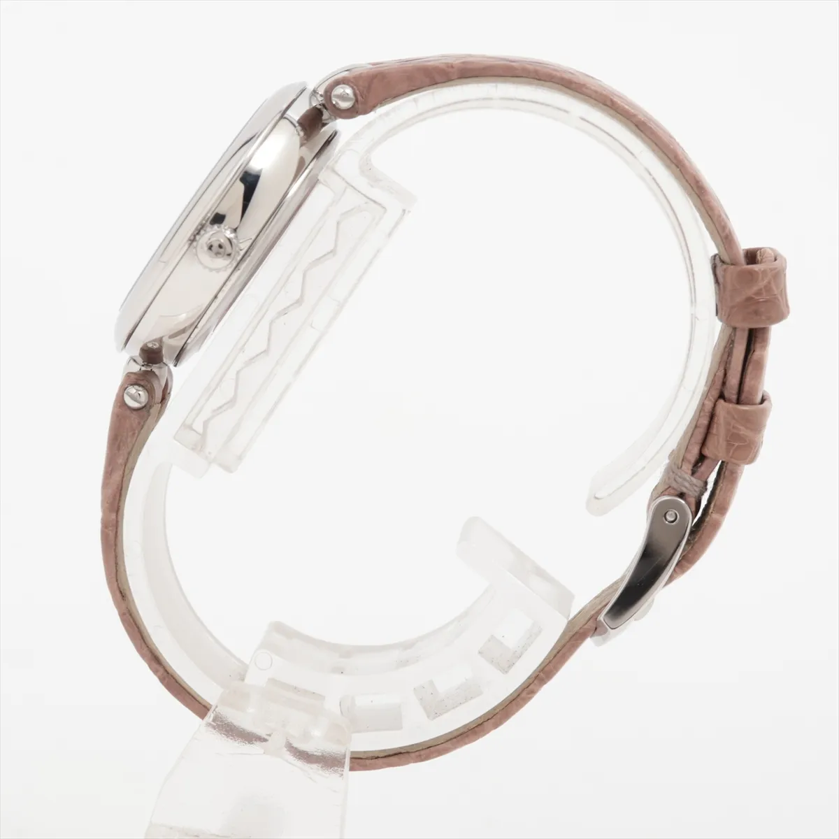 Small round watch with a pale dial and a dark leather strap.
