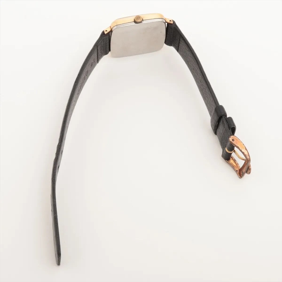 Small gold-tone watch with warm champagne dial and slim baton hands, fitted to a leather strap.