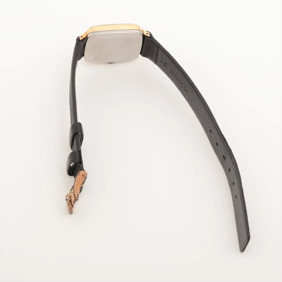 Small gold-tone watch with warm champagne dial and slim baton hands, fitted to a leather strap.