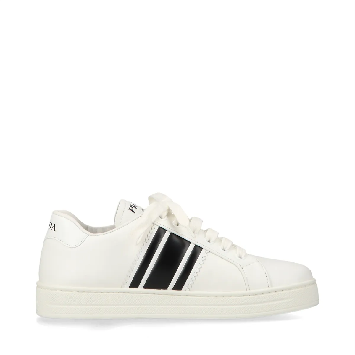 Pair of low-top white leather shoes with black trim, photographed against a plain background.