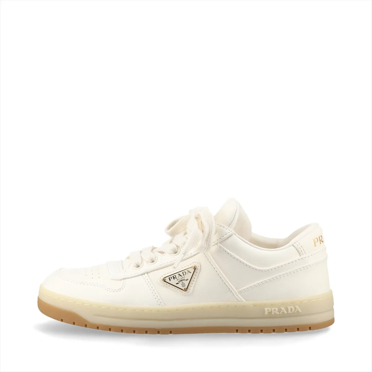 Ivory leather low-top sneakers with a small triangular metal plaque on the side and white soles.