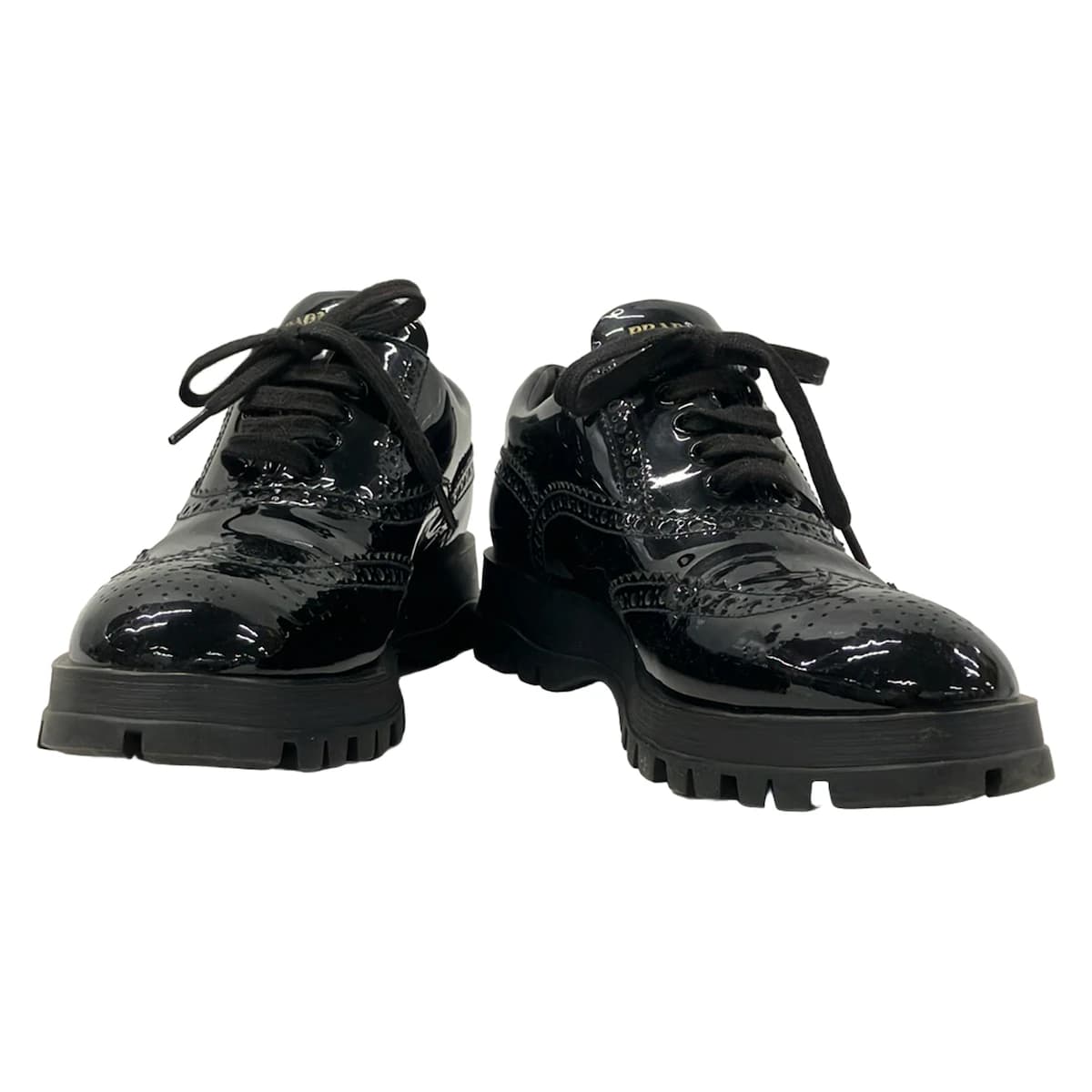 Pair of black leather low-top shoes with laces, shown side on.