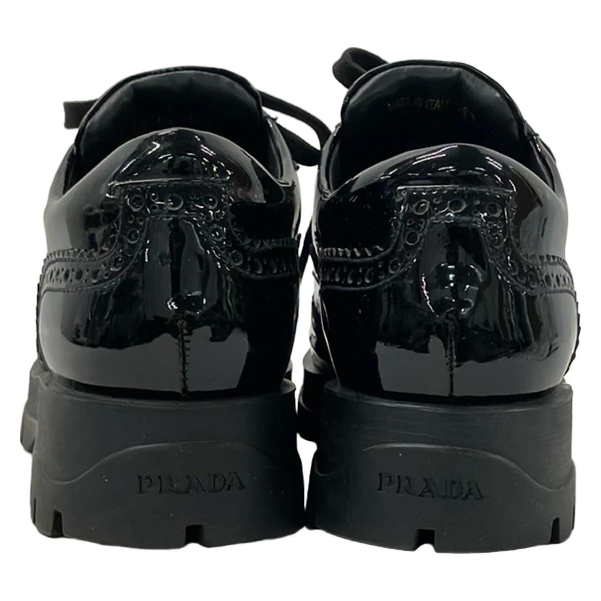 Pair of black leather low-top shoes with laces, shown side on.