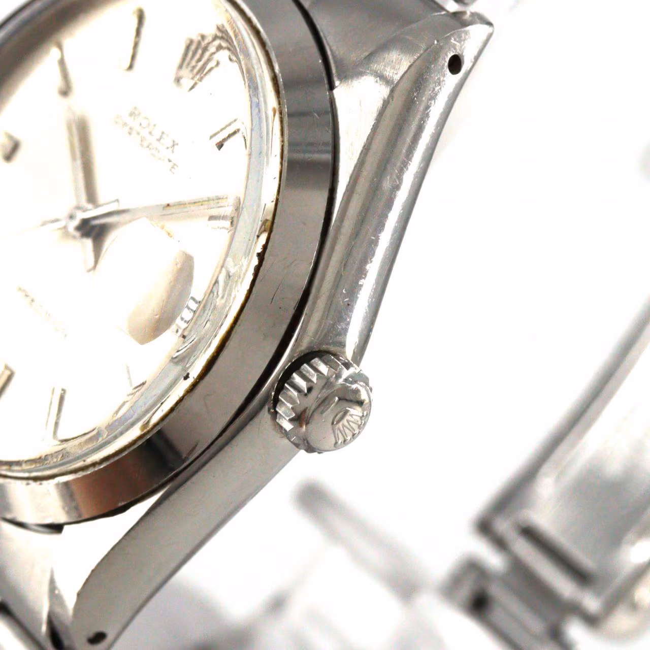 Steel manual-wind wristwatch with date window at three o'clock and steel bracelet.