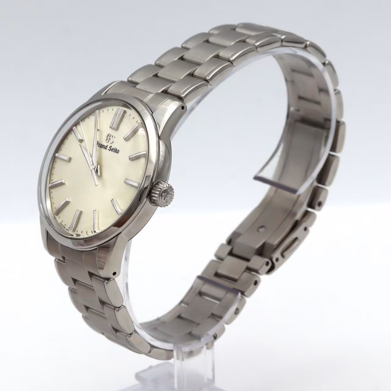 Stainless steel quartz wristwatch with a pale dial, slim baton markers and polished case.