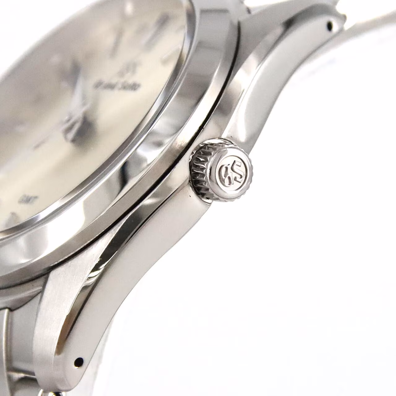 Stainless steel wristwatch with silver dial, blue-tipped GMT hand, date window and steel bracelet.