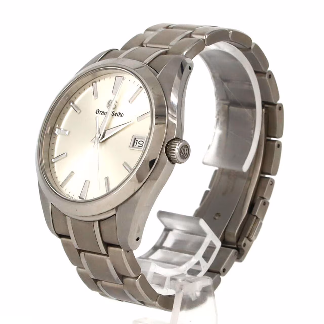 Titanium quartz wristwatch with a light dial, applied baton markers, date window and brushed bracelet.