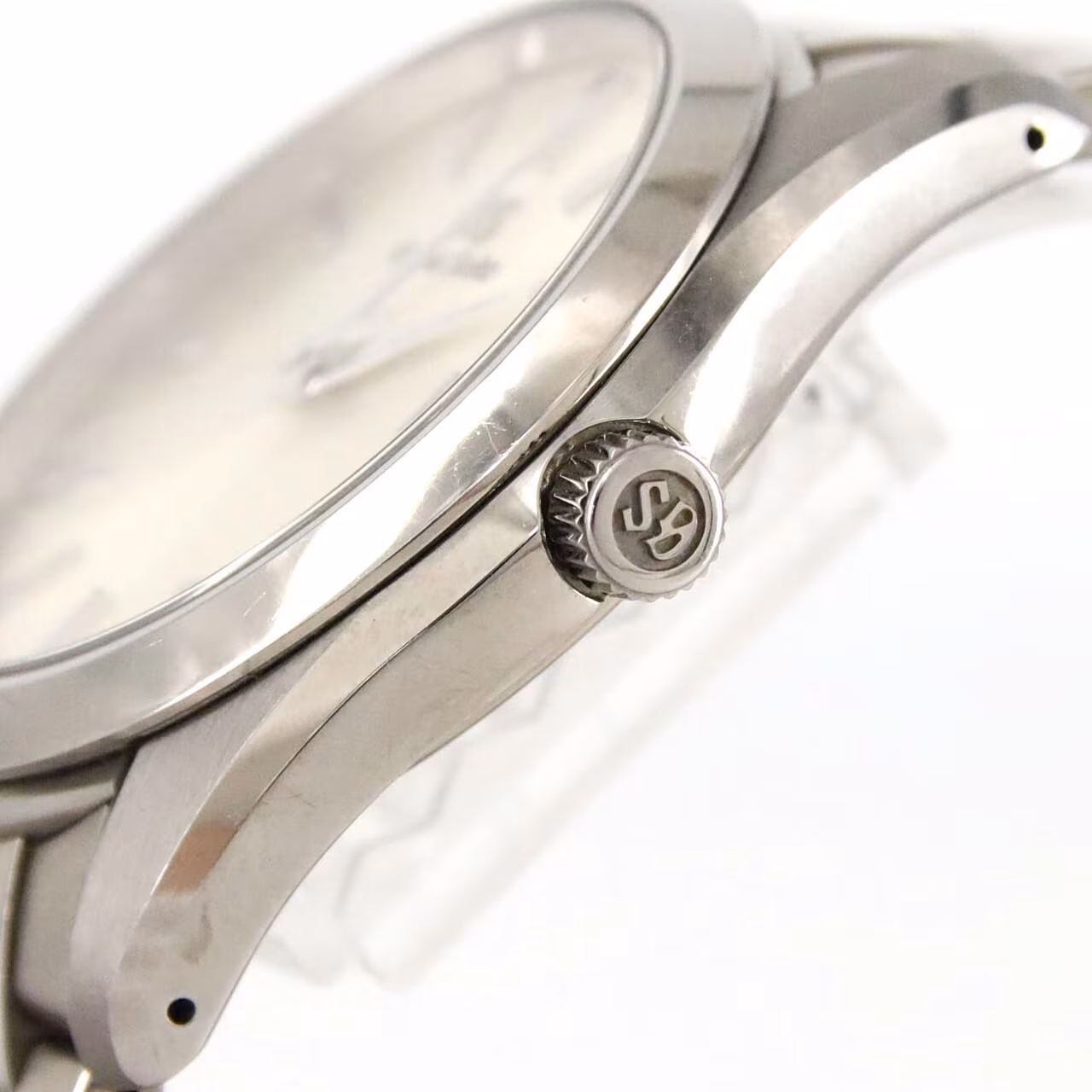 Titanium quartz wristwatch with a light dial, applied baton markers, date window and brushed bracelet.