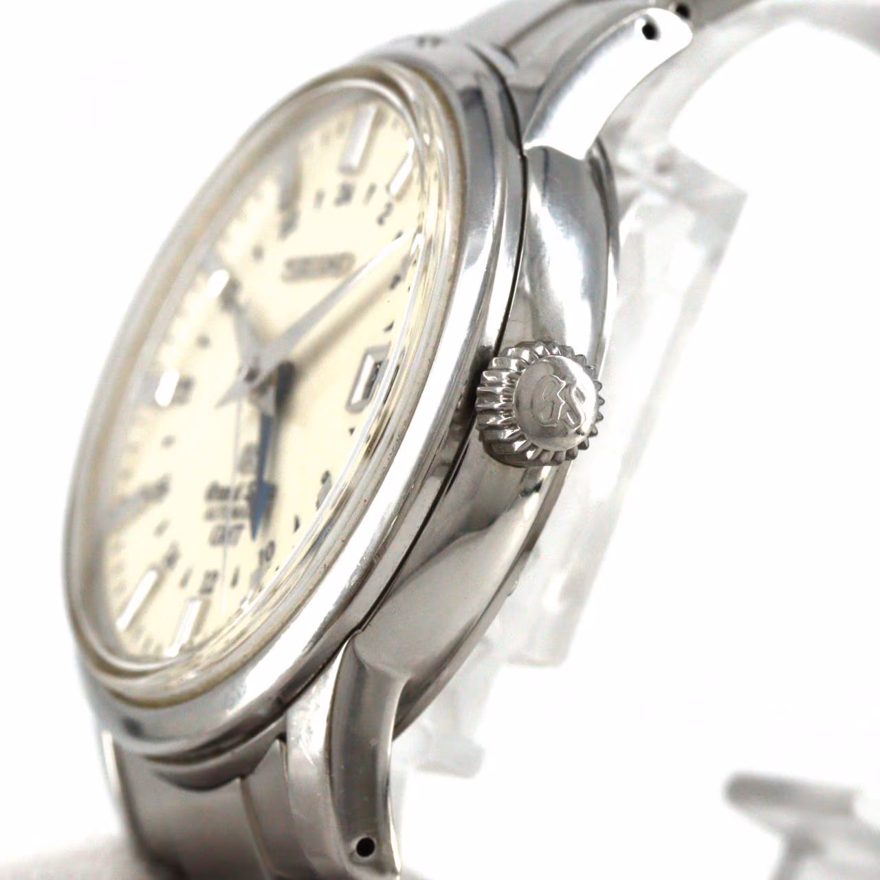 Stainless steel wristwatch with a cream dial, additional GMT hand, date window and steel bracelet.