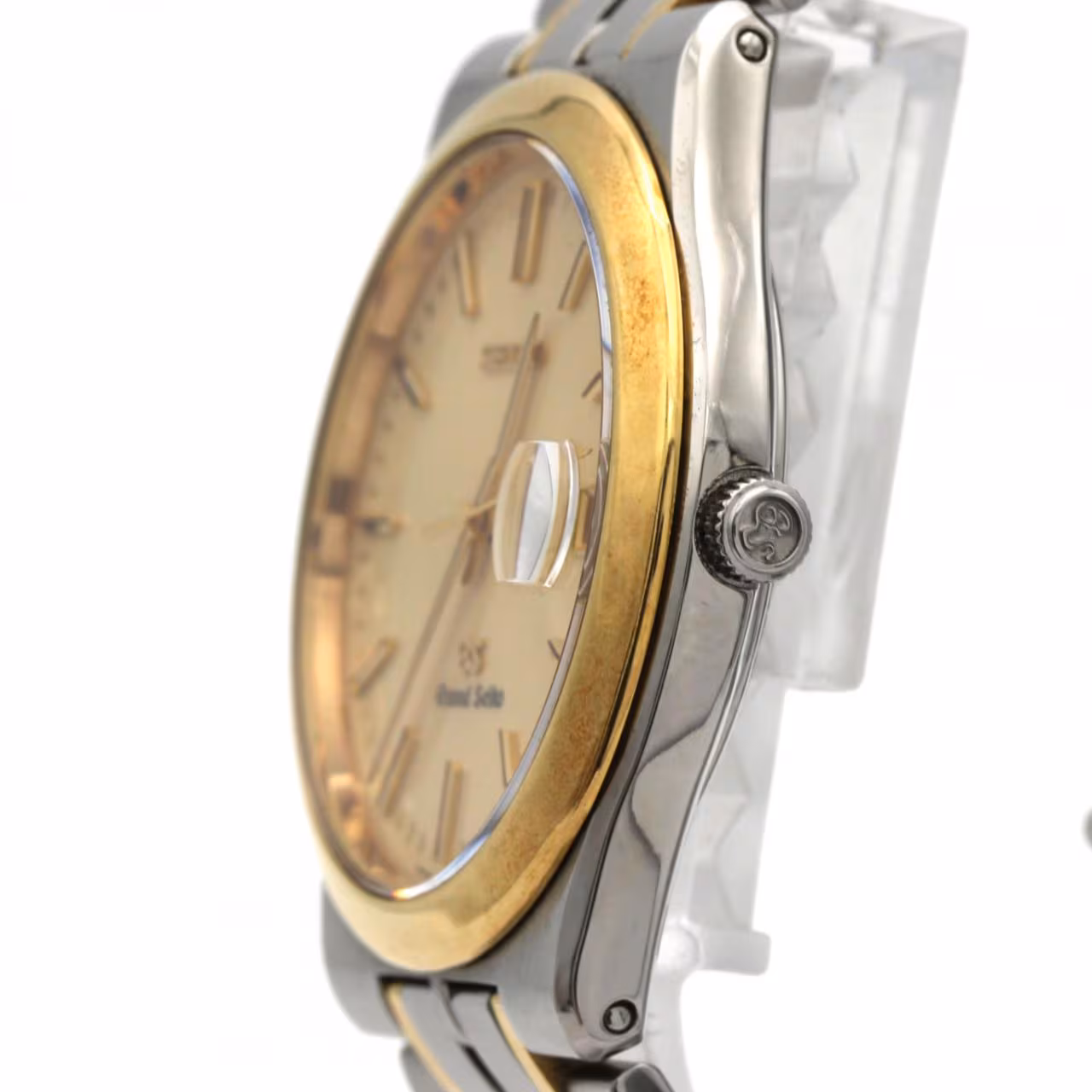 Two-tone wristwatch with steel and gold bracelet links, pale dial, baton markers and date window.