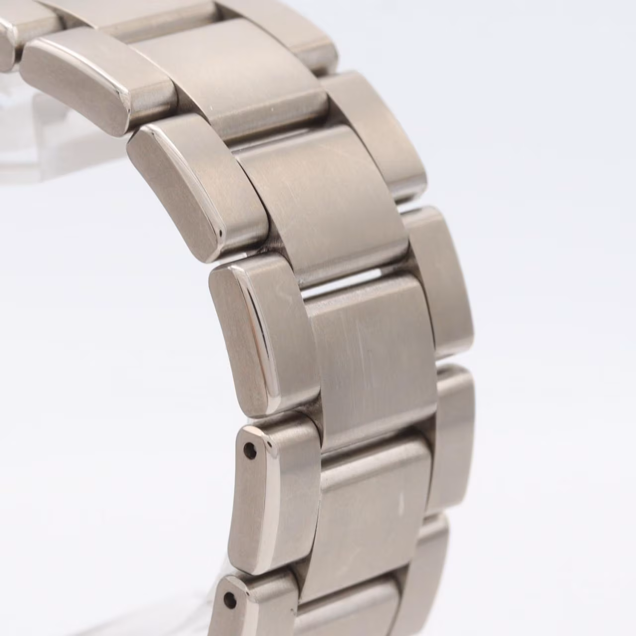 Titanium wristwatch with a light dial, power reserve indicator, date window and brushed bracelet.