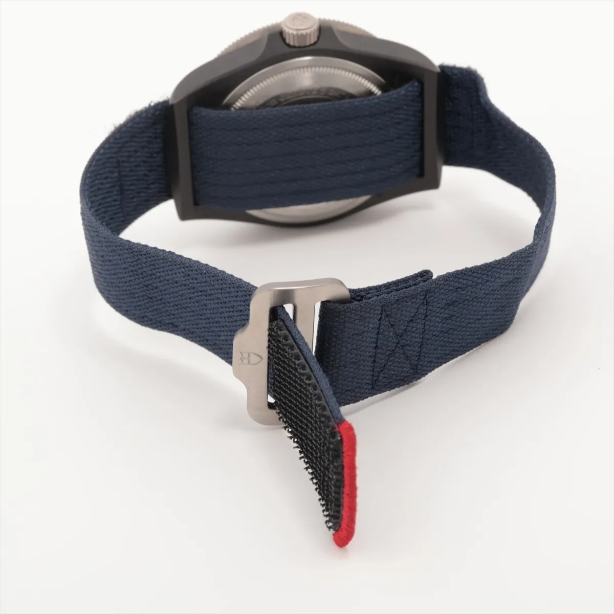 Diver's watch with a dark carbon case, blue dial and matching fabric strap.