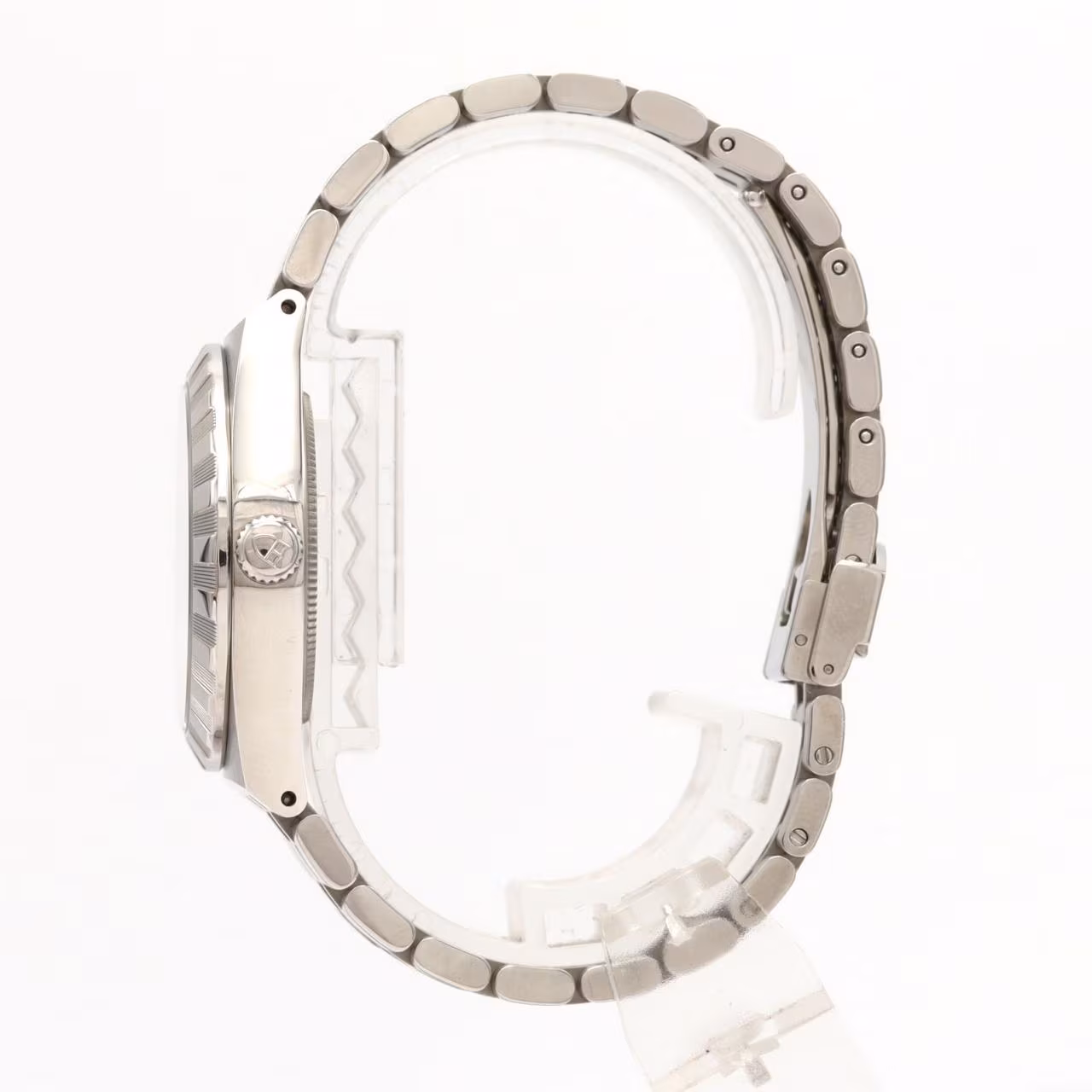 Stainless steel wristwatch with integrated bracelet and fluted bezel on a pale background.