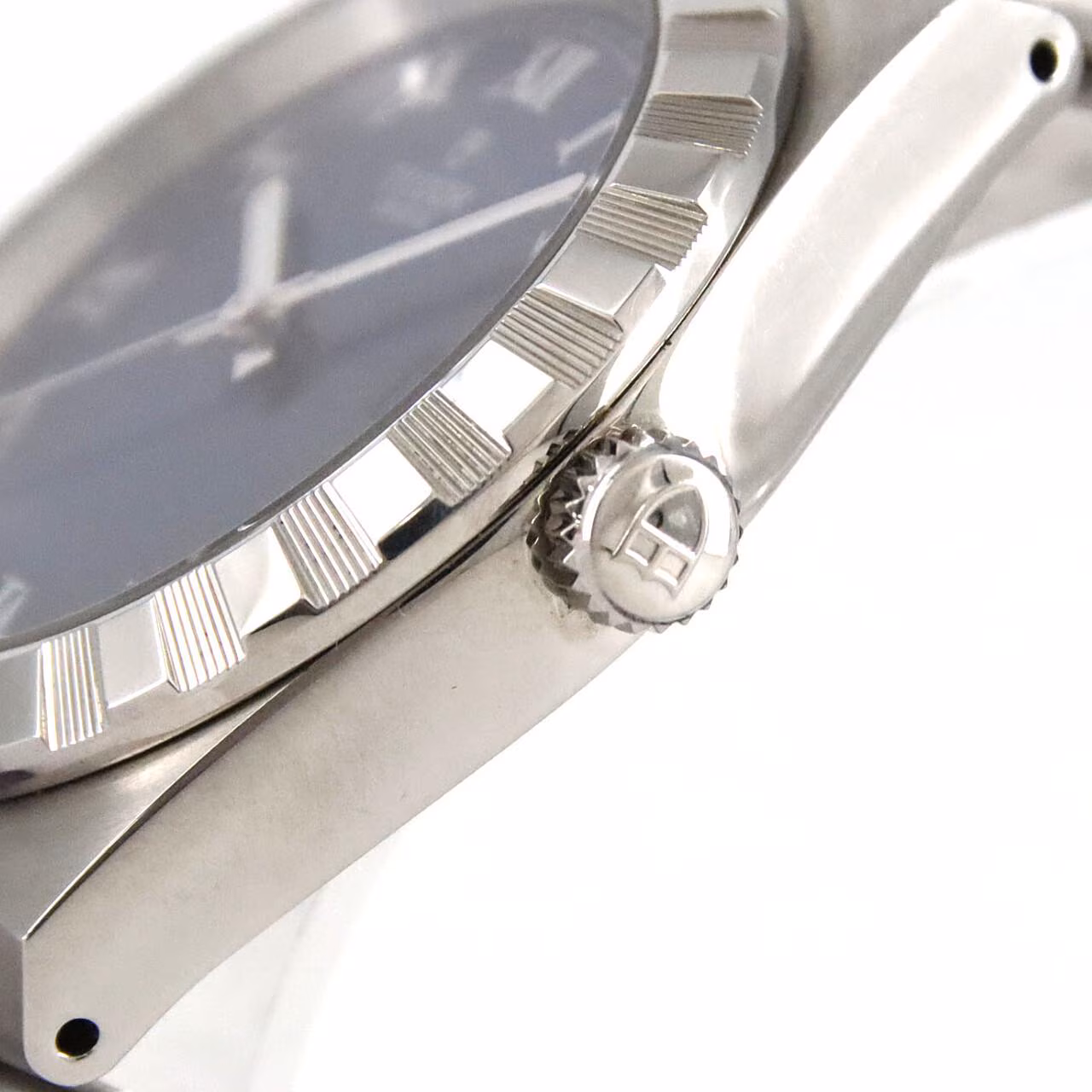 Stainless steel automatic wristwatch with an integrated bracelet and fluted bezel.